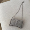 A silver rhinestone-embellished clutch purse